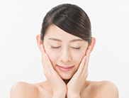 両頬に手を当てて目を閉じている女性